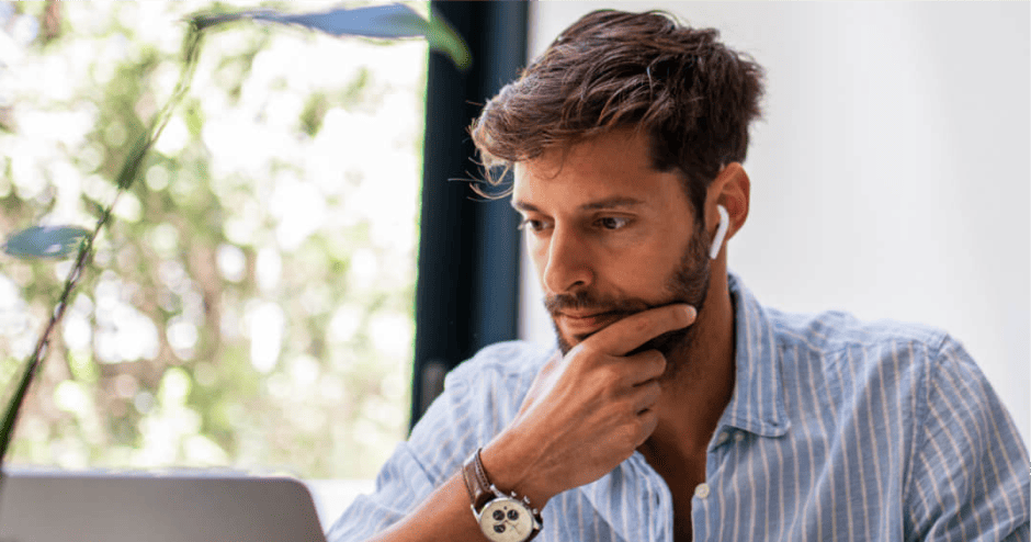 Bančni uslužbenec gleda v monitor in razmišlja.