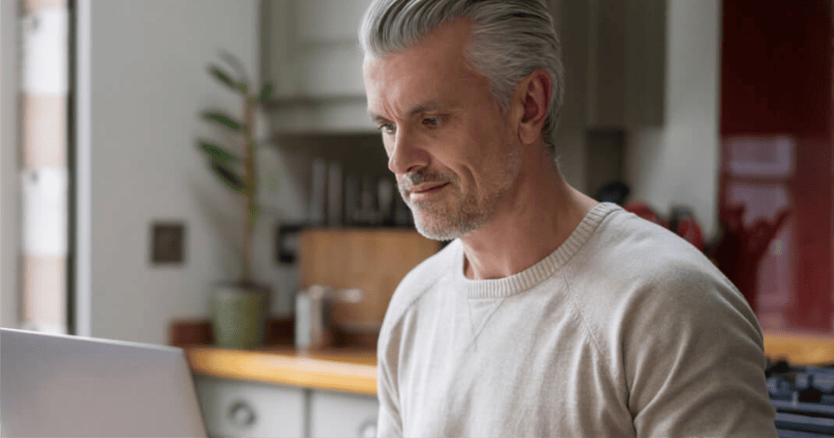 Sodelavec dela na prenosnem računalniku.