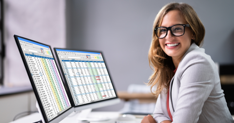 Nasmejana sodelavka sedi za pisalno mizo.